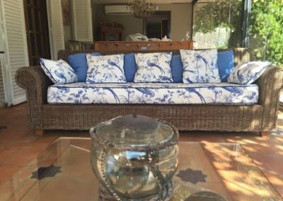 Sofá de mimbre con almohadones de tela de exterior estampado de pájaros azules | El taller de Lis